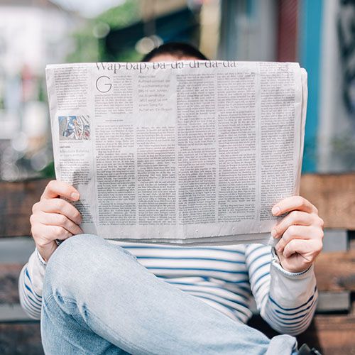 photo personne lisant un journal papier