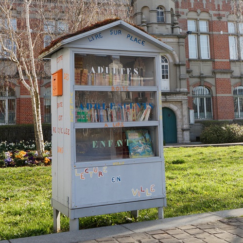 Armoire à livre en forme de maison, dans un parc.